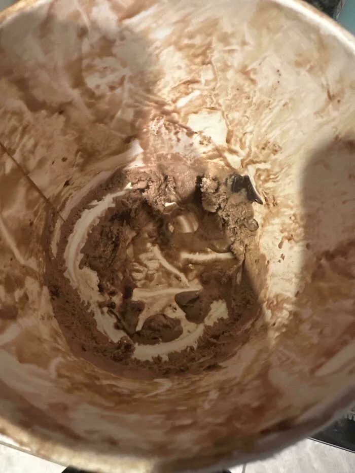 Almost empty ice cream carton with chocolate smears showing minimal effort to finish