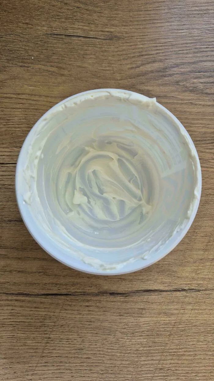 Empty tub with small smear of cream left, capturing the audacity of not throwing it away