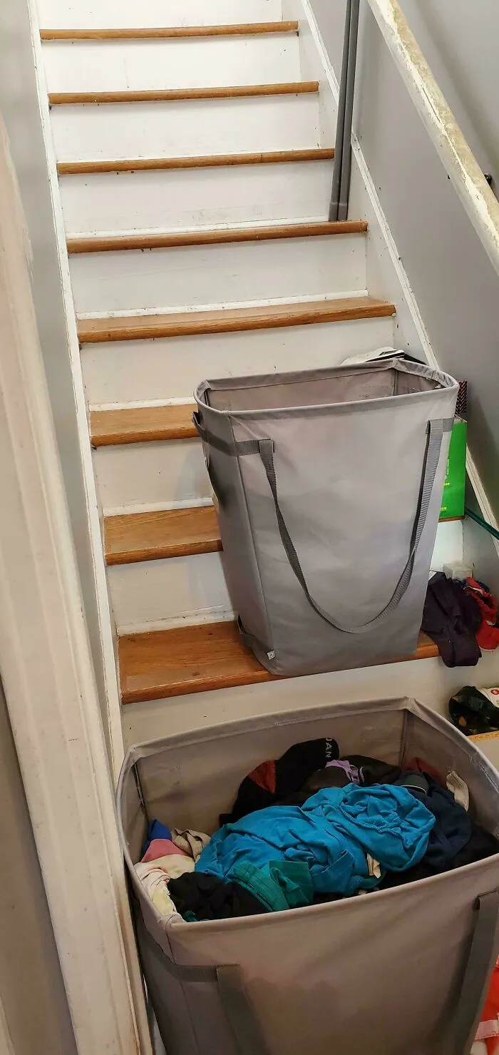 An empty laundry hamper blocking the stairs, showing the sheer audacity of avoiding household chores.