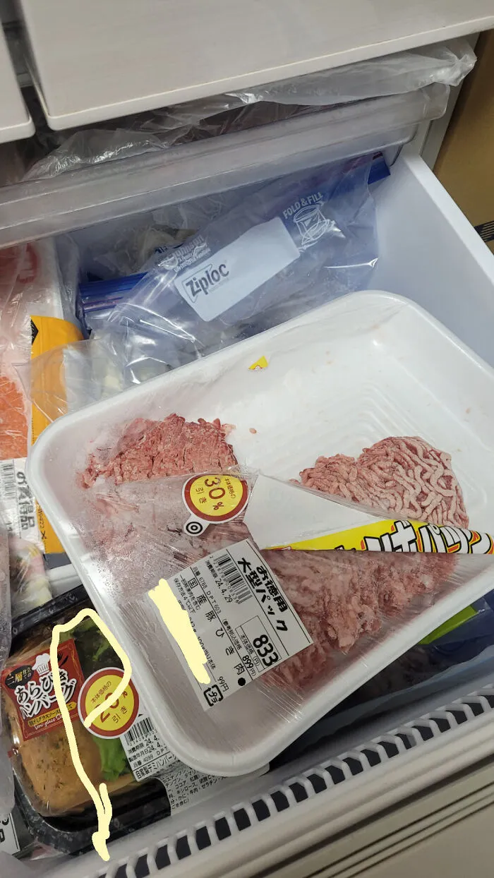 A poorly wrapped tray of ground meat in the fridge capturing the sheer audacity of lazy kitchen habits