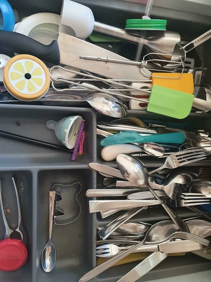 A messy, disorganized kitchen utensil drawer showing the sheer audacity of bad organization
