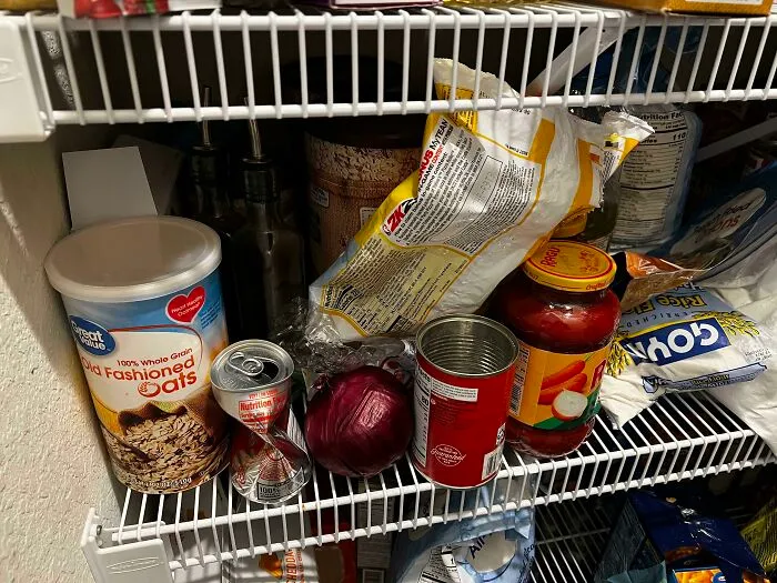 Messy kitchen pantry shelf showcasing the audacity some men have when cleaning up.