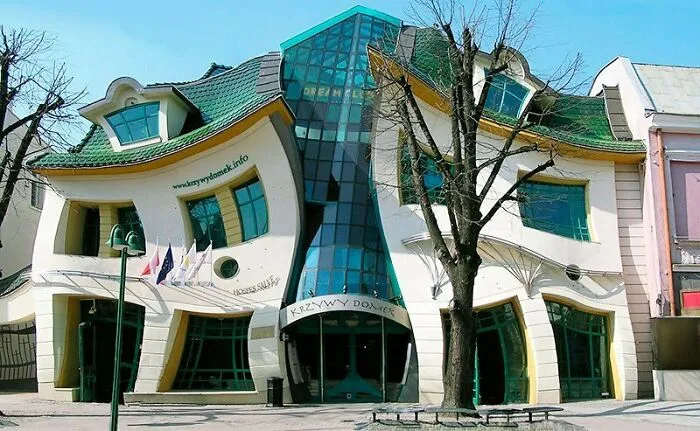 Real pictures of the Crooked House in Poland showing a whimsical and wavy architectural design