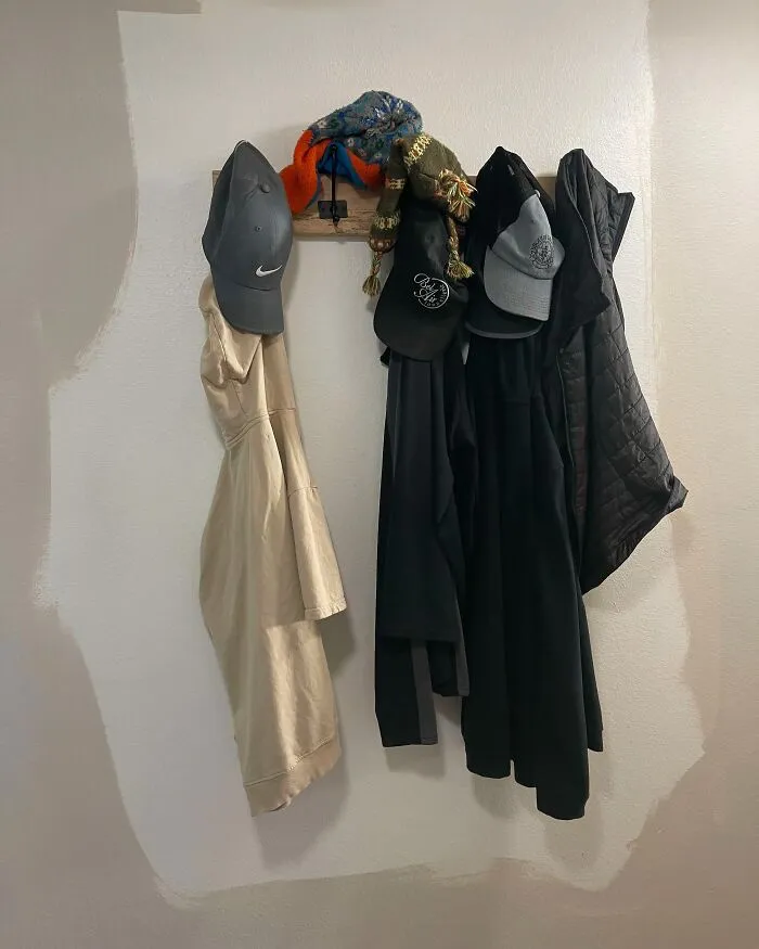 A poorly painted wall around a coat rack, showing the sheer audacity of some men when it comes to DIY work.