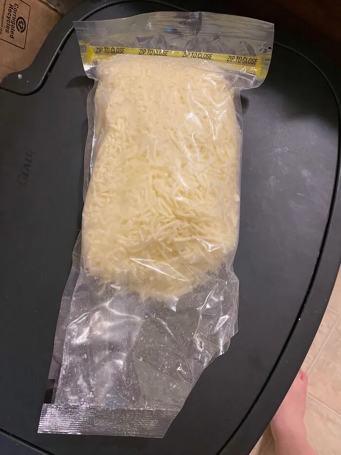A bag of shredded cheese sealed incorrectly with the zip closure at the bottom, capturing sheer audacity