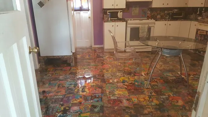 A kitchen floor completely covered in comic books, illustrating unusual choices in houses and interior design.