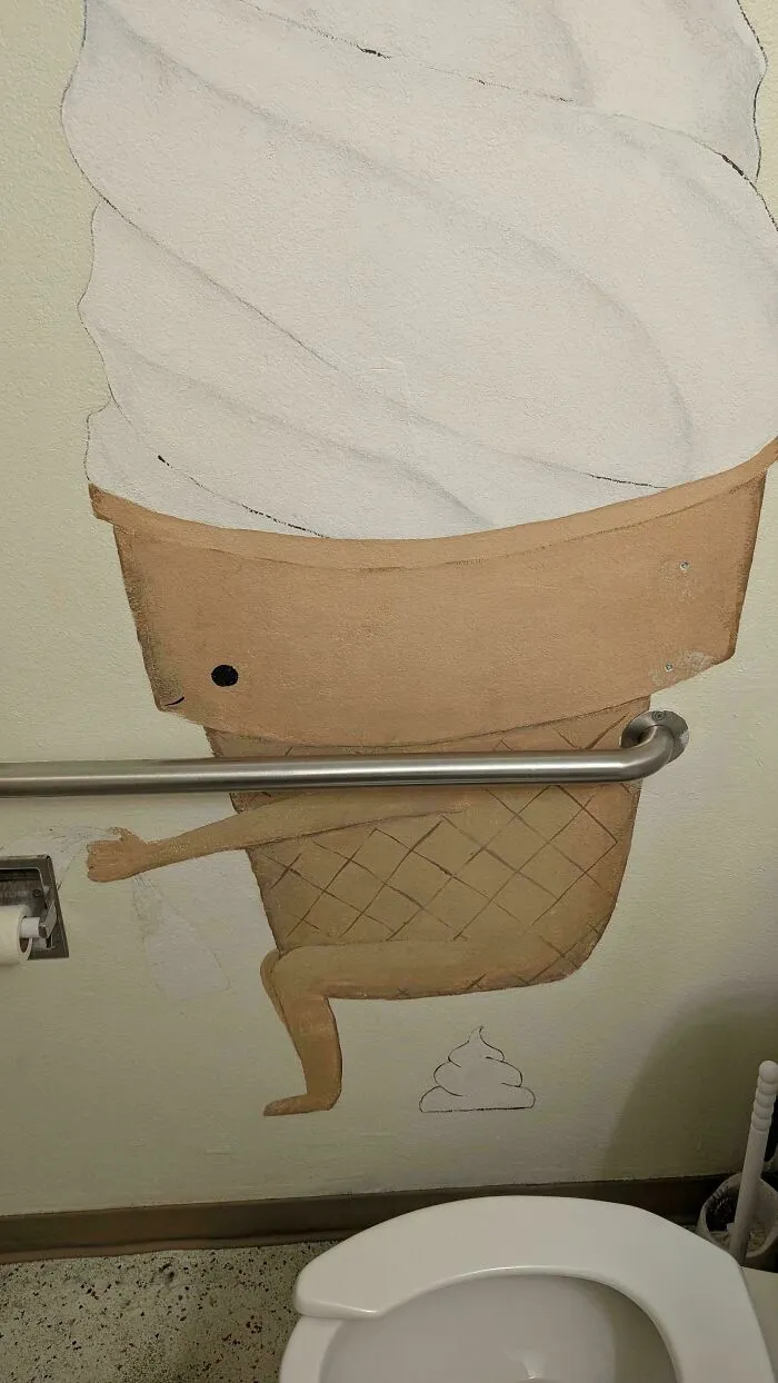 A bathroom wall painting depicting an ice cream cone sitting on a toilet, among awful creations in art.
