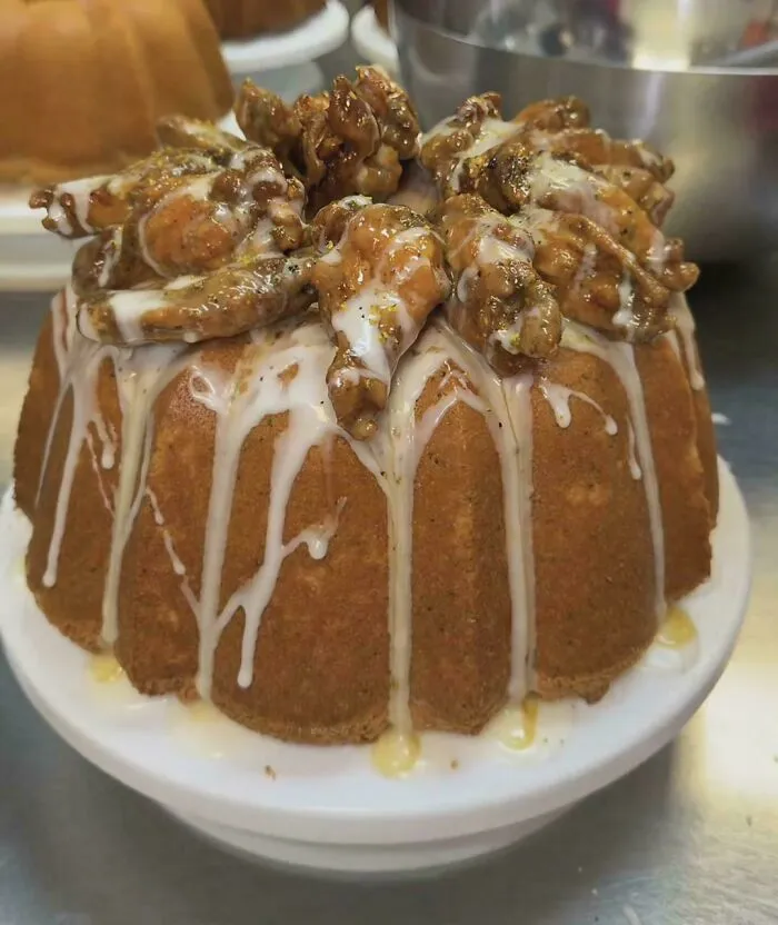 A bundt cake glazed with icing and topped with fried chicken wings, highlighting well made creations awful to look at.