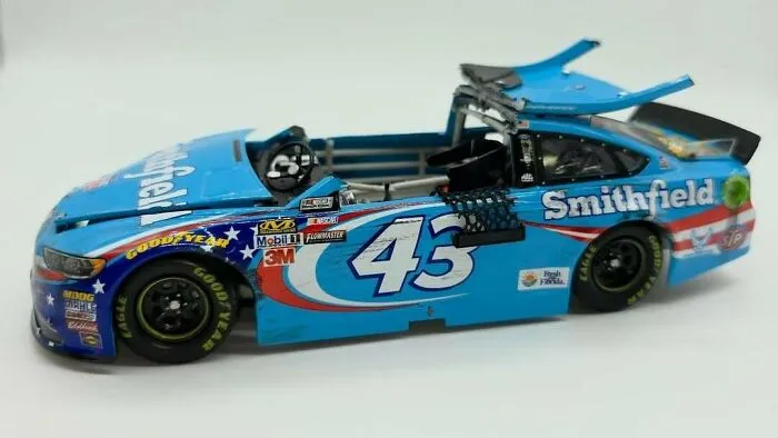 Blue toy race car missing its roof and windshield, an awful creation far too well-made to ignore.