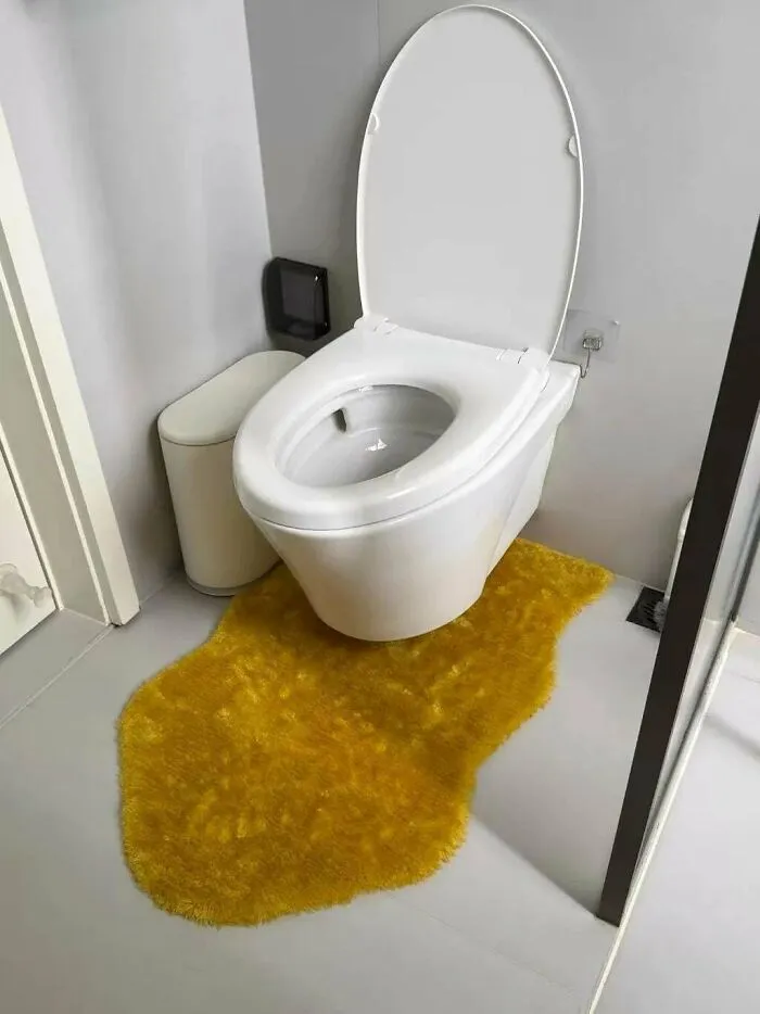 A white toilet sitting over a yellow fuzzy rug, showcasing unique creations and awful execution.