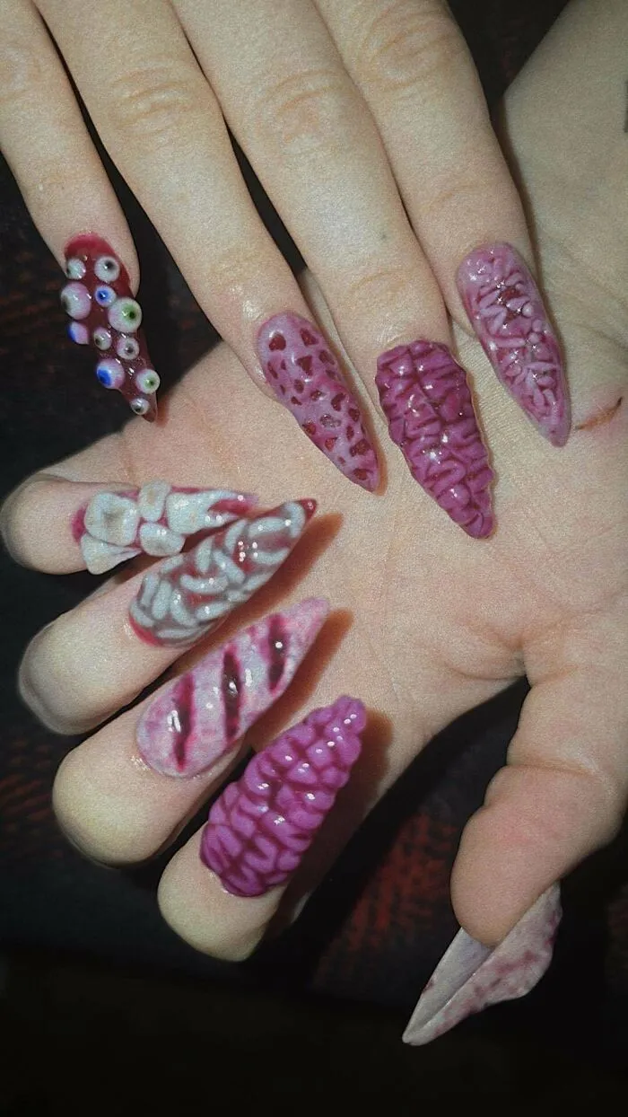 Detailed creepy nail art featuring flesh and teeth textures, one of many creations awful to look at but well-made.