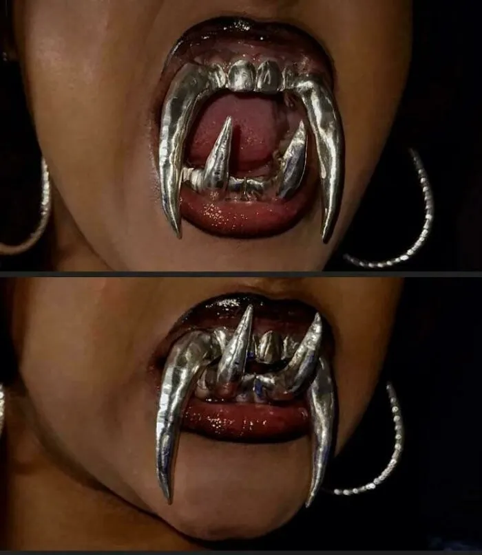 Custom silver fang grills on teeth as awful to look at creations.