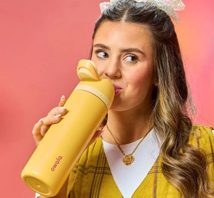 A woman drinks from a yellow Owala water bottle, highlighted in Prime Big Deal Days.