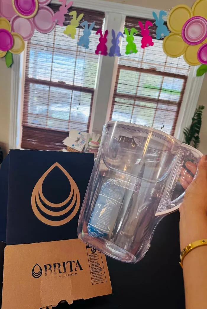 A clear Brita water filter pitcher held in front of its box, a great find from Prime Big Deal Days