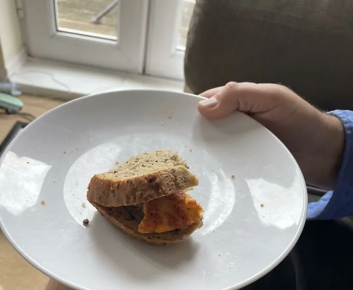 A small pizza slice inside a bread sandwich, showcasing weird food combinations.