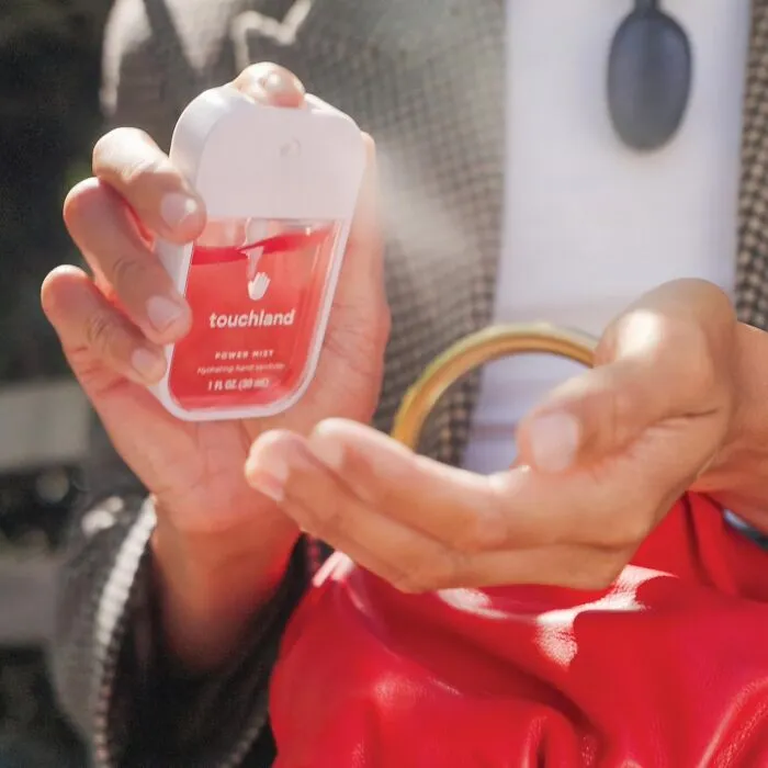 Hands spraying Touchland hand sanitizer, featured in Prime Big Deal Days selection.