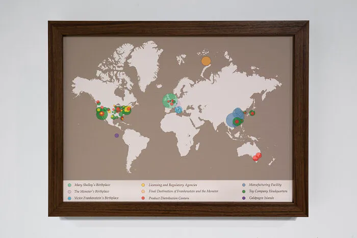 A framed map of the world with colorful data visualization circles resembling unusual sculptures data