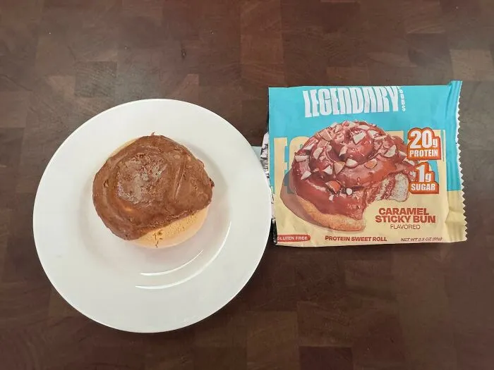 A sweet roll glazed with chocolate beside its packaging, highlighting creative food combinations.