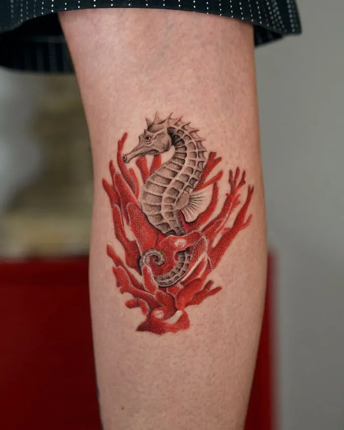 Seahorse tattoo with red coral nature ink design on leg