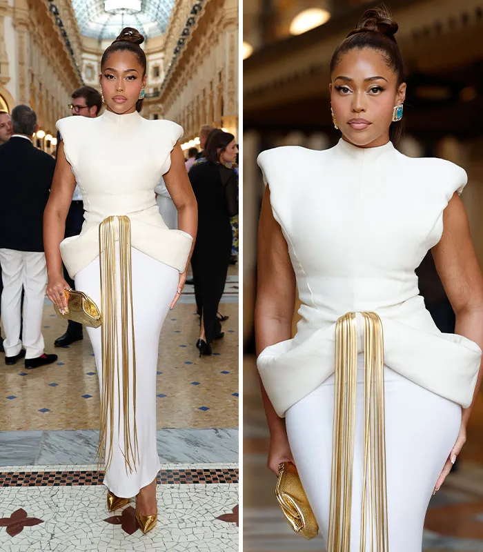 Fashionable guest in white dress with gold accents at plastic surgery expo