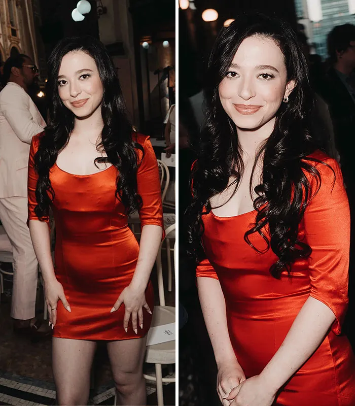 Woman in red satin dress smiling at plastic surgery expo