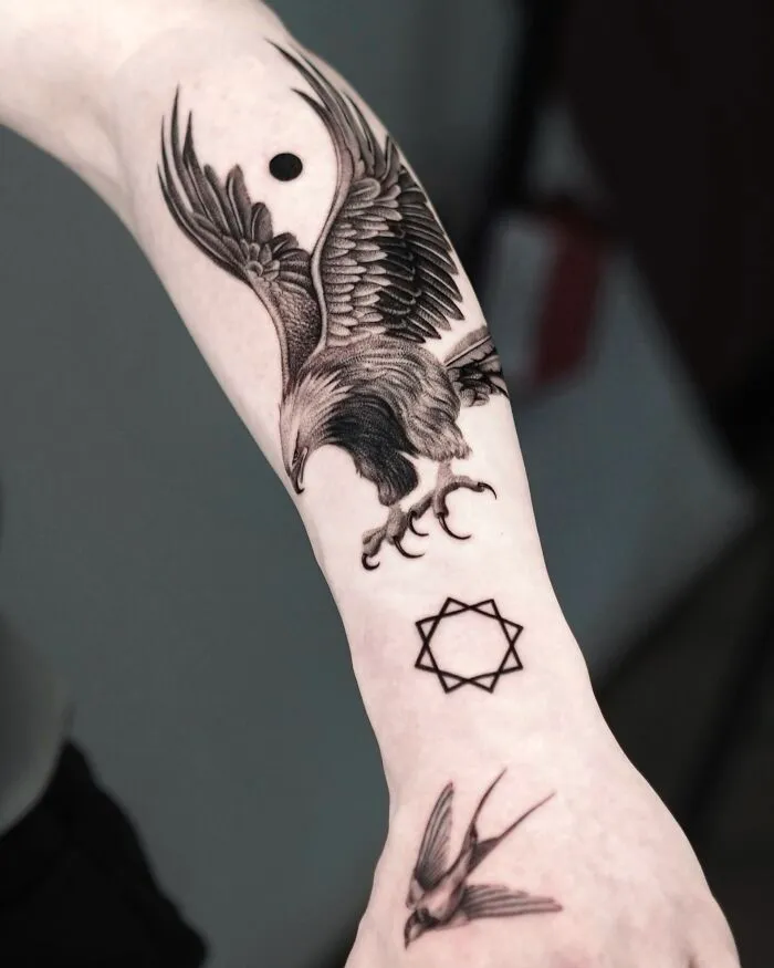 Detailed black ink eagle tattoo with bird and star symbol on arm