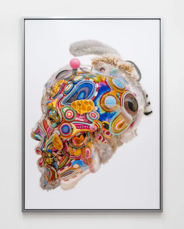 A vibrant piece from unusual sculptures depicting a head covered in intricate multicolored thread patterns