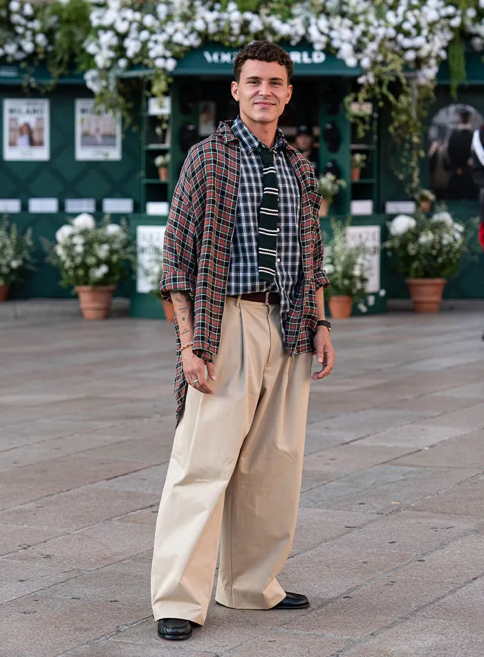 Man in layered plaid and checked outfit at Plastic Surgery Expo fashion event