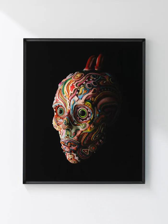 Framed surreal skull-like face crafted from vibrant multi-layered fabrics, representative of unusual sculptures.