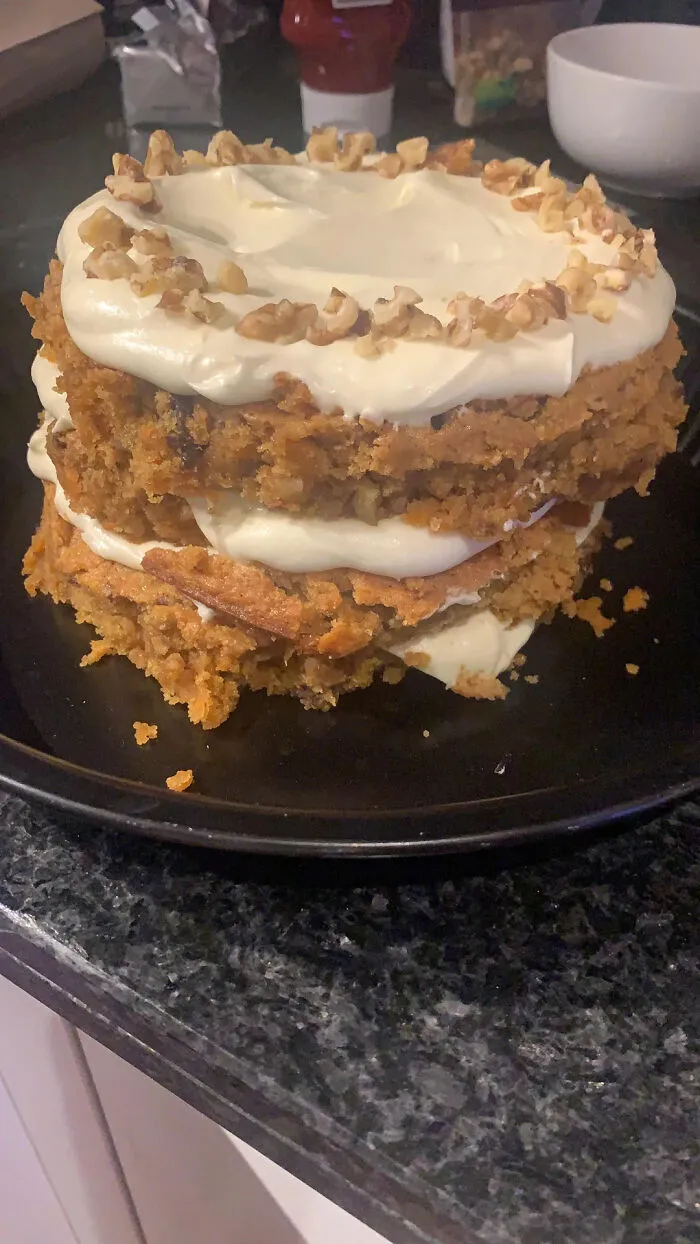 Lumpy homemade carrot cake with frosting and walnut pieces