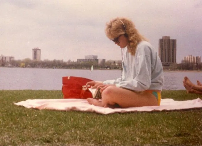 Young Woman With A Walkman While Reading And Smoking