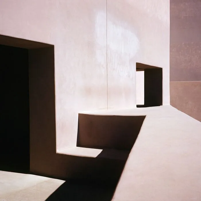 Minimalist analog film photo showing shadows and geometric shapes on wall