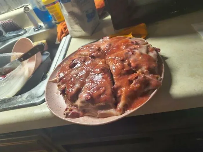 Strange food combinations with a whole pizza covered entirely in thick red strawberry glaze on a plate