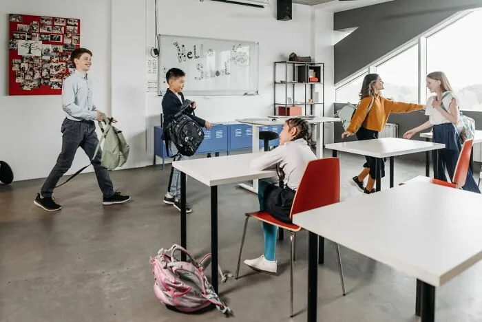 Students interacting and packing bags in a classroom, recalling the busy atmosphere of a school day