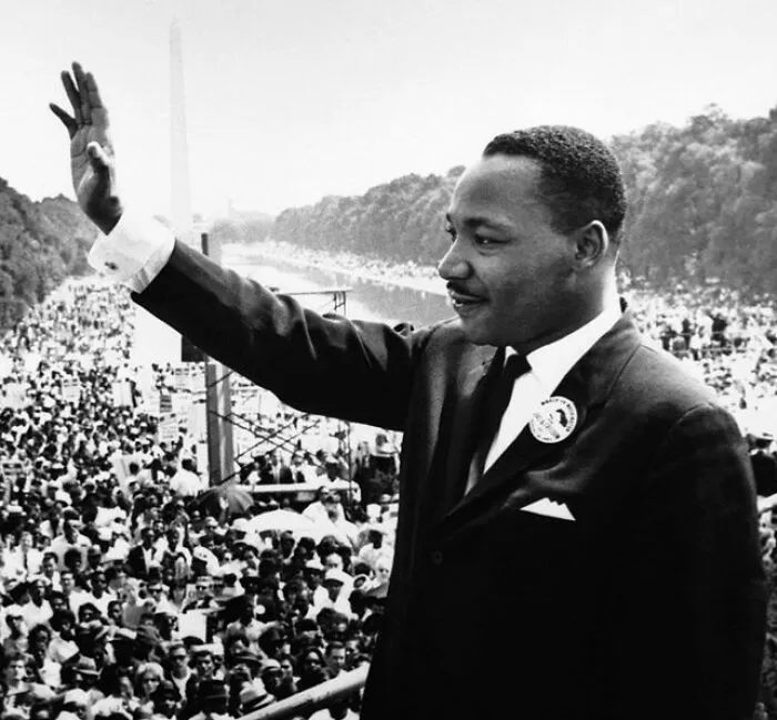 Historical photo of Martin Luther King Jr waving during a march, recalling powerful teachers of history