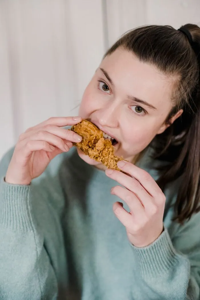 A girl eating fried chicken, showing a humorous example of students common sense vacation in class