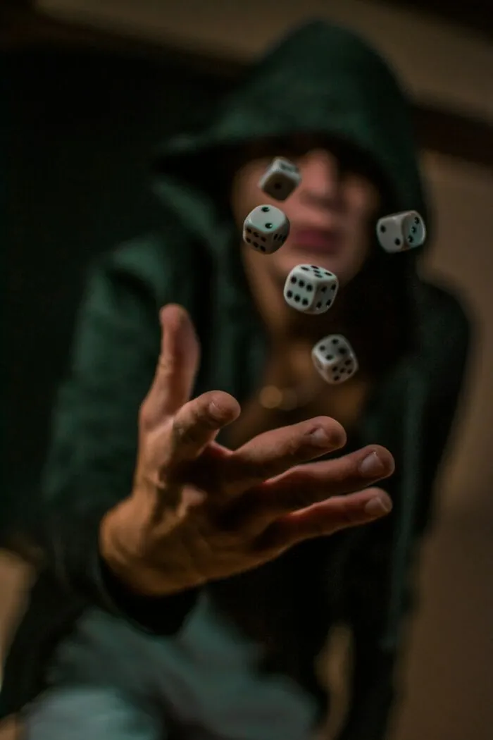 Person in green hoodie throws dice in the air, representing teachers recall of students common sense