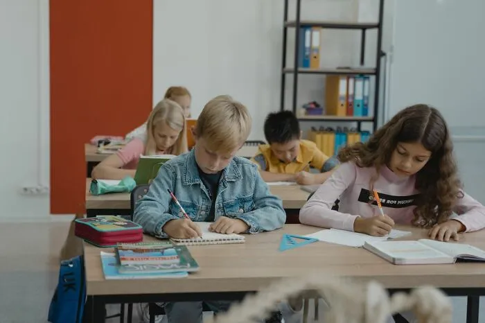 Students sitting at desks in a classroom, where some lack common sense according to teachers