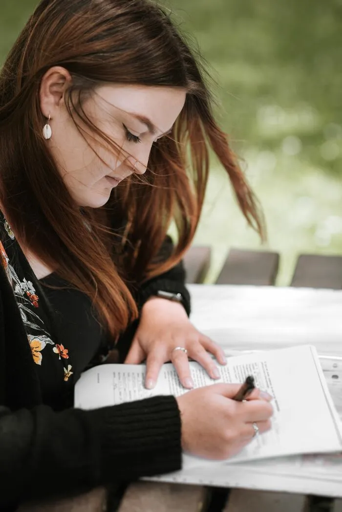 A teacher writing notes on a document during a lesson about students
