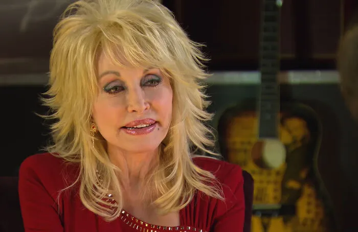 Country singer Dolly Parton in a red dress, illustrating interesting new facts