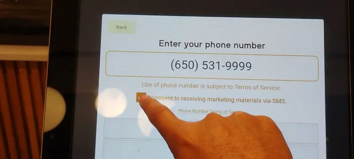 An on-screen prompt requiring SMS marketing consent to proceed, an example of terrible product design.