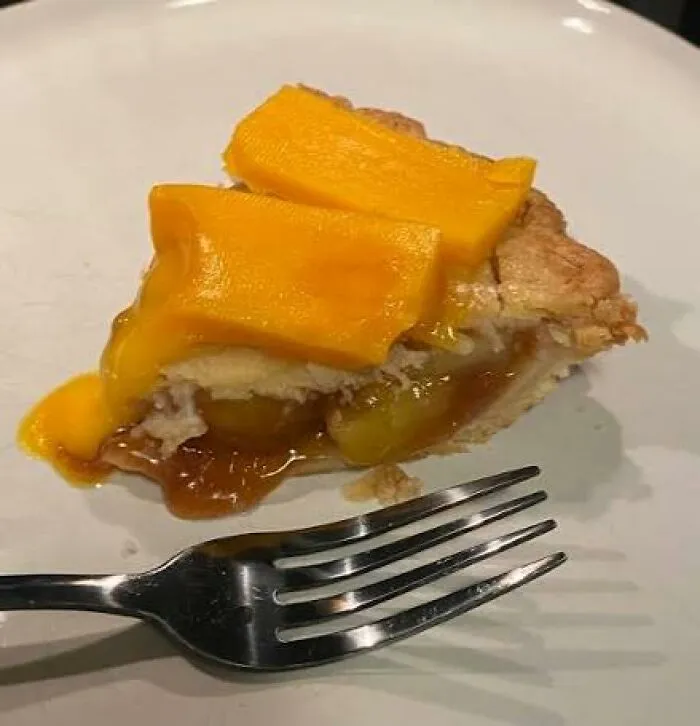 A slice of apple pie topped with melted cheddar cheese, highlighting odd food combinations