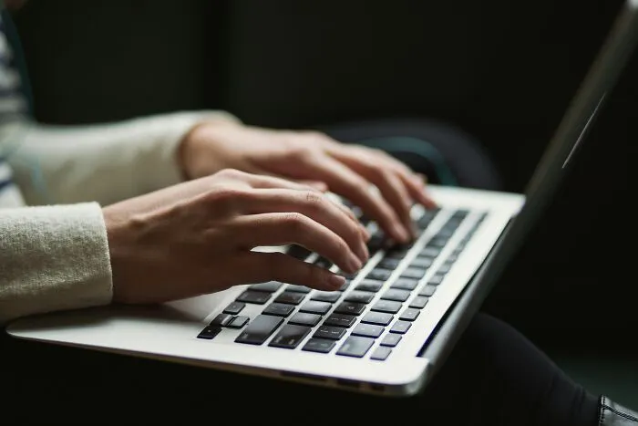 Close-up of hands typing on a laptop keyboard, highlighting digital work trends