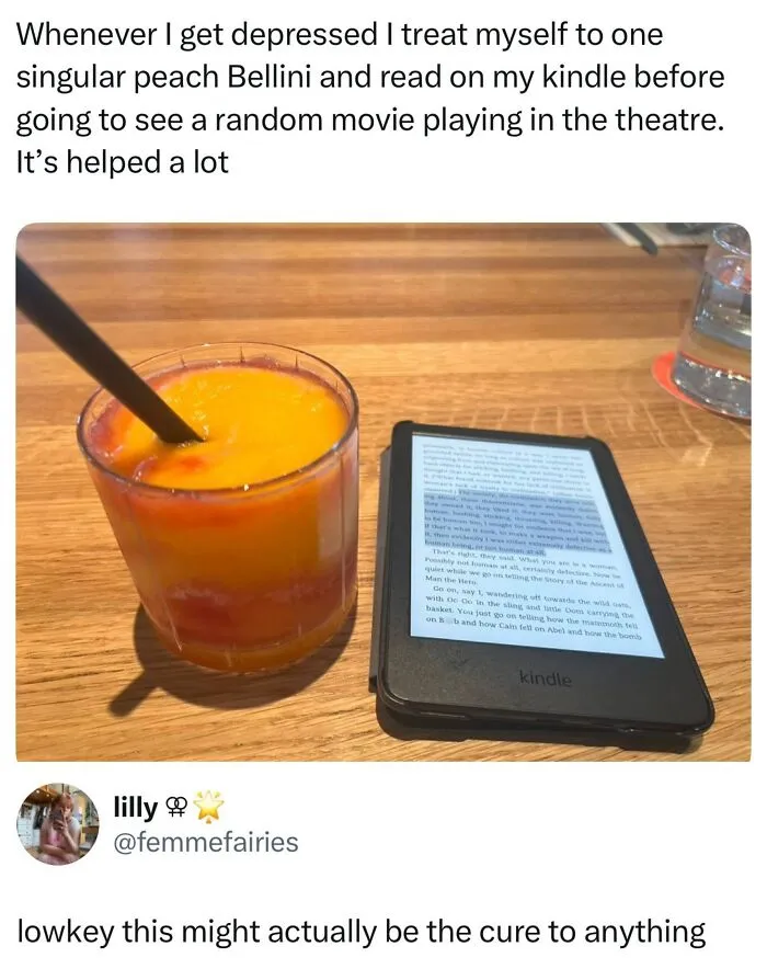 Peach Bellini cocktail next to a Kindle e-reader on wooden table wellness meme