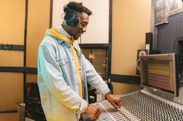 A man wearing headphones adjusts a sound mixing board, revealing some Hollywood secrets and rumors.