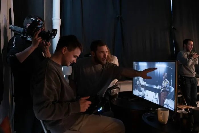 A film crew reviews footage, discussing Hollywood secrets and rumors on set.
