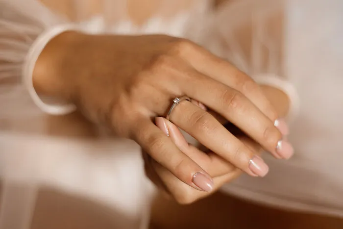 A woman wearing a simple ring, symbolizing the beginning of a life free of marriage regrets.