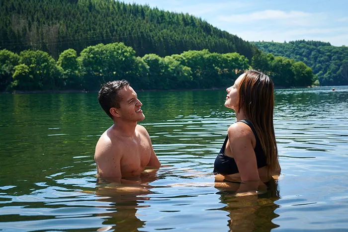 A couple in water, looking happy, symbolizing a marriage proposal and making the right choice.