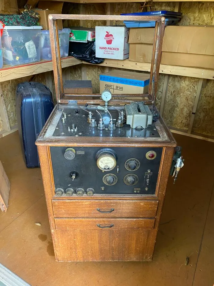 An antique wooden medical device cabinet showing the medical history of early diagnostic machines.