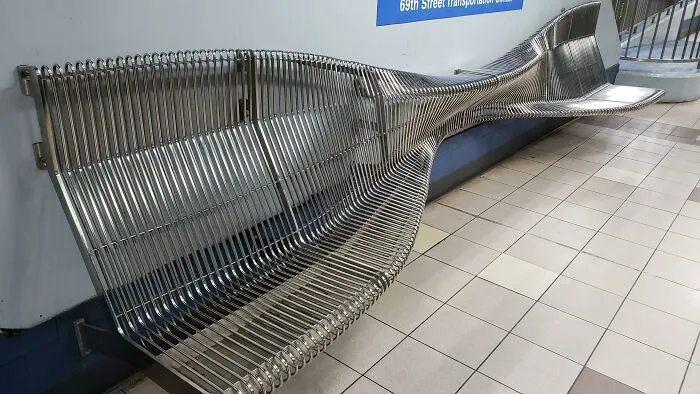 Uncomfortable wavy metal bench at a transit station illustrating Terrible Product Design